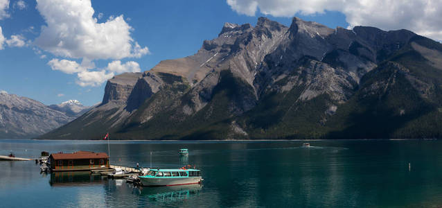 船在船坞与美丽的加拿大山风景在背景。拍摄于加拿大艾伯塔省班夫 Minnewanka 湖