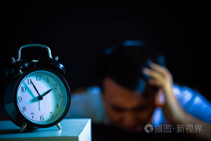 亚洲男人在床上痛苦思考他的问题,晚上的失眠和睡眠障碍