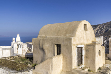 港口边缘一层有半圆形屋顶的小石头房子矗立在一个小希腊山村里俯瞰