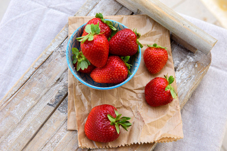 新鲜的草莓放在一个木盘子里的碗里。选择性聚焦