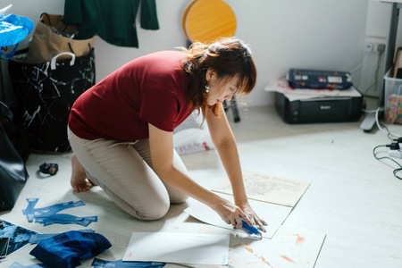 亚洲女企业家工作在她的设计坐在地板上