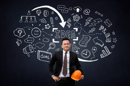 工程师的头站在黑色的黑板前与许多想法白色图标照片