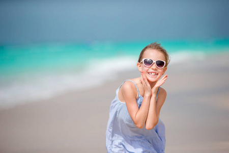 美丽的小女孩在海滩的礼服乐趣