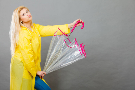 快乐的金发女人,穿黄色的雨衣透明打伞乐趣照片