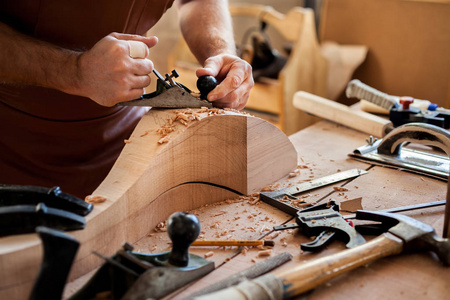 木匠做 Cabriole 腿为古董桌。木匠工作与一个刨床在车间为生产古董家具。他使 cabriole 的腿, 在路易斯 Xv 和