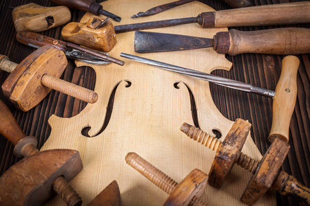 小提琴肚皮和木桌上的不同工作工具