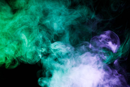 在黑色的孤立背景上的绿色和蓝色的颜色密集的五彩烟雾。烟雾 vape 背景