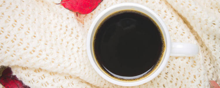 大杯热咖啡在秋天设置与一条围巾，木制的桌子上的毛衣。舒适 温馨 舒适