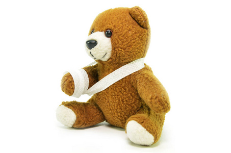 白色背景带绷带的泰迪熊受伤