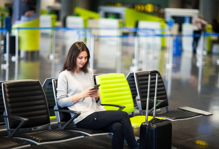 国际机场的年轻女子使用智能手机