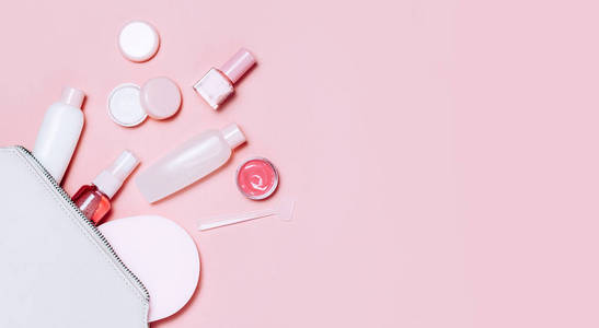 美丽的装饰化妆品和奶油设置从化妆品袋在粉红色的背景。Copyspace 为您的文本。简约的化妆品风格。顶部视图, 平躺