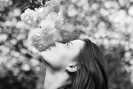 女人与浪漫的脸嗅到白色或象牙玫瑰
