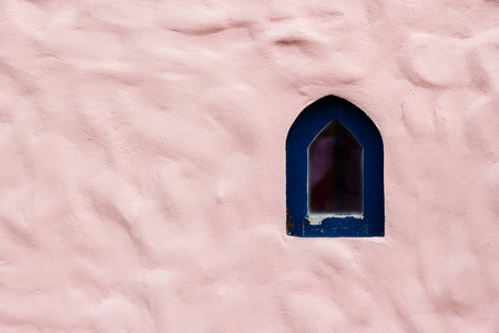 粉红色混凝土墙花纹波浪形小窗口。抽象粉红色水泥墙。装饰的抽象背景