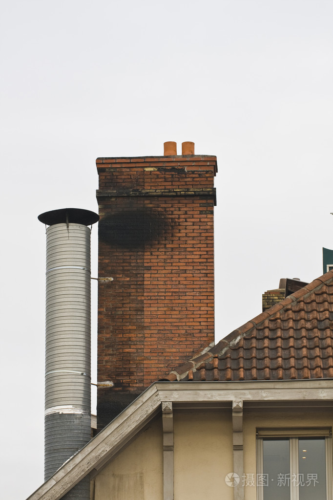 红砖烟囱和金属平铺屋顶上的烟囱