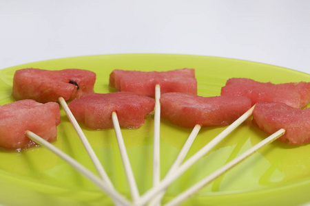 西瓜的果肉是用邮票切碎的。它们被赋予不同的形式。在烤肉串上的弦