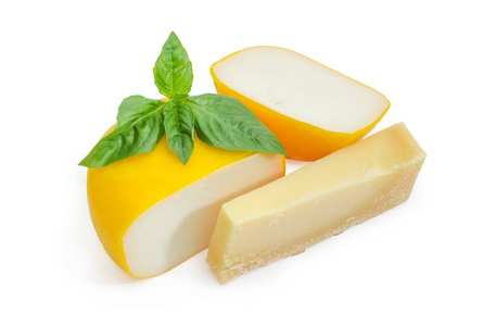 小轮的山羊奶酪切成两部分和一块的帕尔马干酪与树枝的绿色罗勒在一个白色的背景