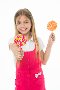 小孩子微笑着, 用白棒糖隔开。快乐的女孩拿着棍子上的糖果。和你分享糖果。Candyshop 概念。童年和幸福。孩子用漩涡奶糖微笑