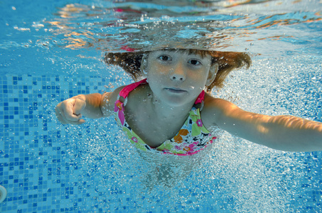 快乐的微笑水下孩子在游泳池