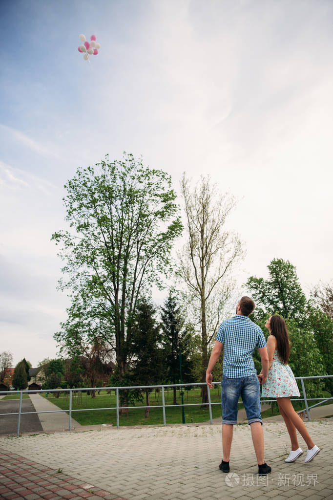 情侣在户外爱英俊的男人和美丽的女人在一个春天盛开的公园散步他们让