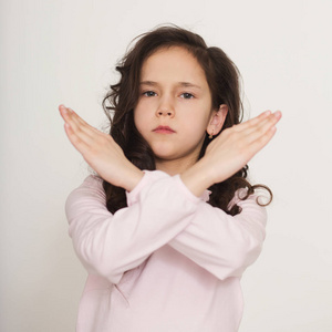 小女孩展示交叉的胳膊照片