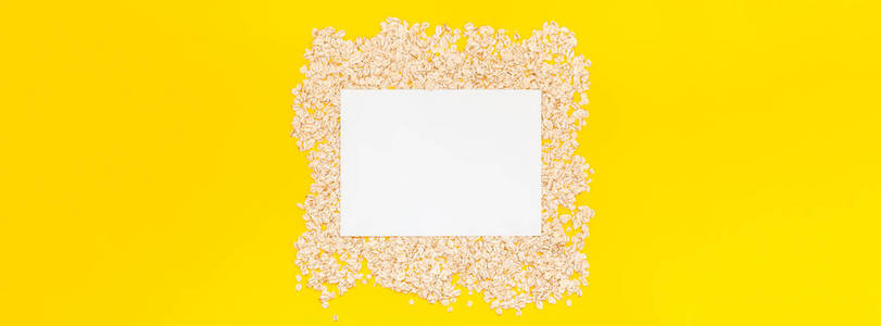 创意平躺概念燕麦片的健康和素食有机食品早餐在明亮的黄色纸长宽横幅以极小的样式复制空间