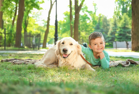 可爱的小孩子与他的宠物在绿色公园照片