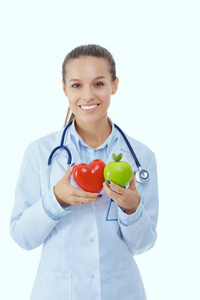 美丽的微笑女医生拿着红色的心和青苹果。女医生