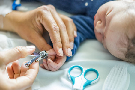 母亲在医院里割下她刚出生的男婴的指甲。