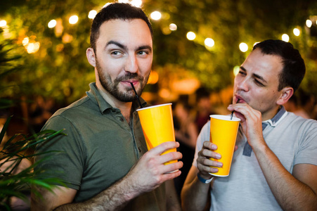 酗酒者在户外咖啡馆或公园里喝酒, 玩得很开心。微笑情侣酒精友谊概念