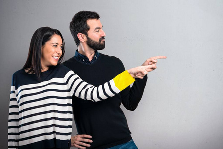 浪漫的亚洲情侣游客看着视线和指向与手指孤立的白色背景选择,购物