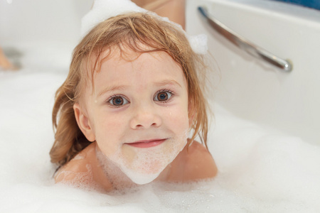 可爱的四岁女孩轻松洗澡用泡沫