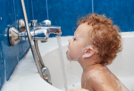 轻松洗澡用泡沫的可爱一岁男孩
