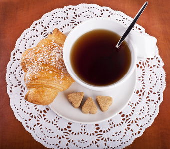 牛角面包和一杯茶或咖啡的俯视图照片