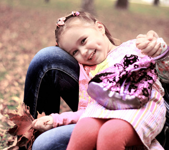 可爱的小女孩在草地上的一个夏天的黄色枫叶叶