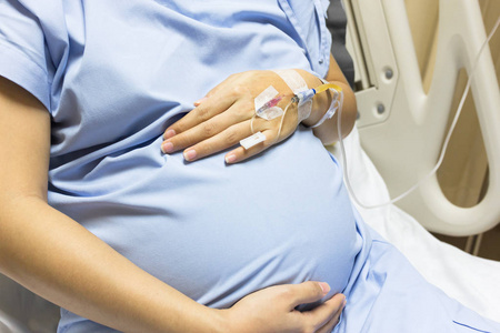 亚洲孕妇病人在病床上接受盐水治疗, 在医院贵宾室, 选择性重点