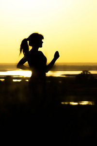 一个女人的剪影在自然的日落, 体育女性形象, 体育, 休闲和保健的概念