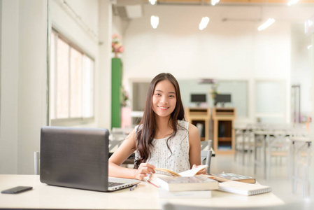 美丽的女性在大学图书馆读书和研究