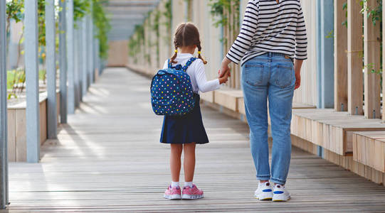 在学校的第一天。母亲带领一个小孩子学校女孩在第一个毕业生