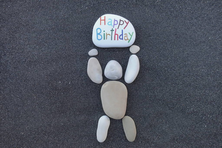 卵石设计人拿着一块石头与雕刻和彩色的消息, 为一个快乐的生日