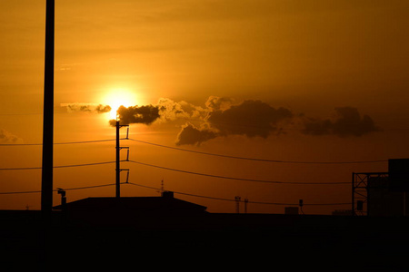 拥有美丽天空的大功率输电塔在前黑暗的日子里是金色的. 日落和大功率输电塔