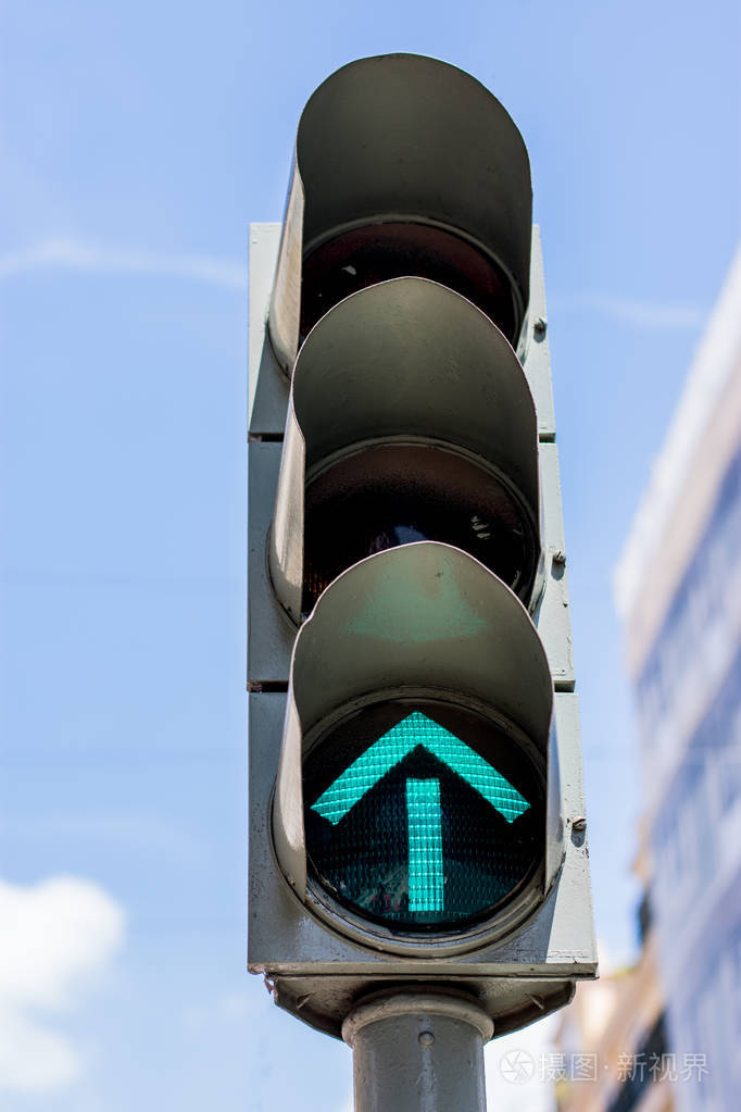 绿色箭头siganlling在红绿灯上行驶背景为蓝天