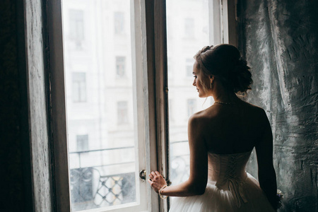 年轻美丽的新娘摆在窗口