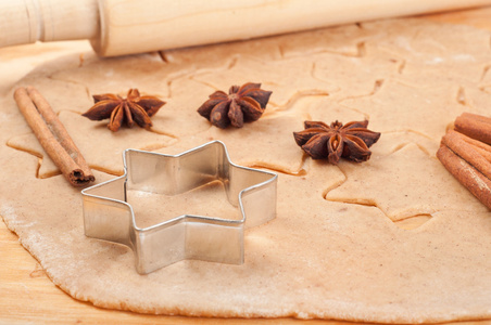 ca圣诞节姜饼饼干与香料和坚果在木制表自制的姜酊或啤酒的木制背景