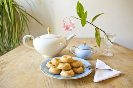 一盘饼干 茶壶和木桌上的一朵花