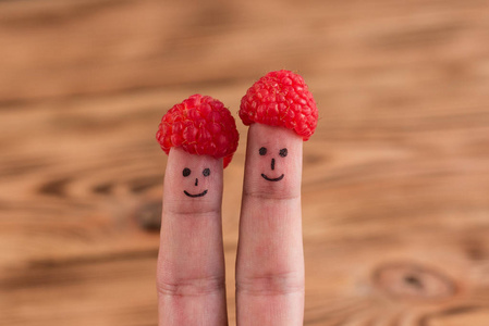 两个微笑的面孔画在手指在帽子从树莓