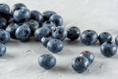 蓝莓的灰色水泥背景。成熟和多汁新鲜的蓝莓特写。一堆浆果特写