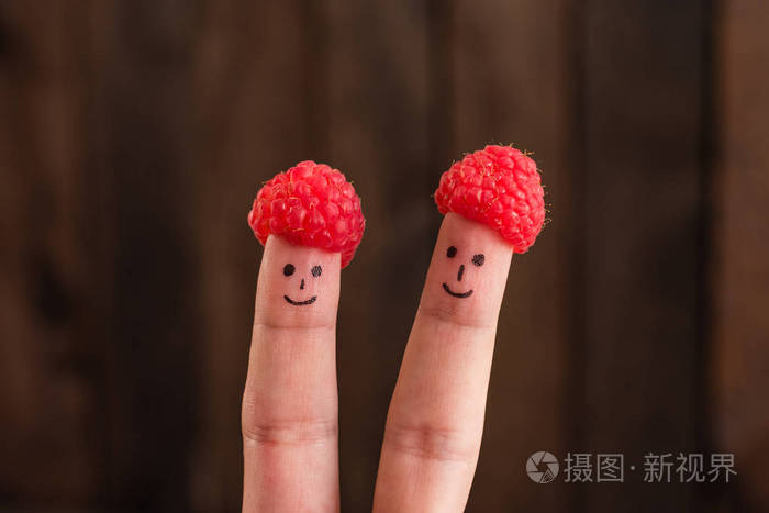 两个微笑的面孔画在手指在帽子从树莓