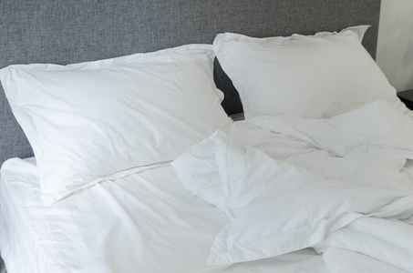 细节在卧室, 一个空床, 白色枕头和毯子关闭, 皱巴巴的床上用品, 晨