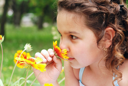 小女孩嗅到花