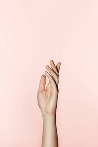女性用手指着粉红色背景的镜头